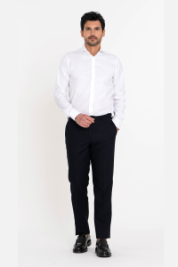 Man lopend in een wit strijkvrij overhemd met lange mouw op een blauwe pantalon in de broek gedragen.