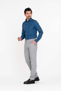 Opzij kijkende jongeman in een grijze pantalon met daarop een donkerblauw techno overhemd in 4 way stretch.