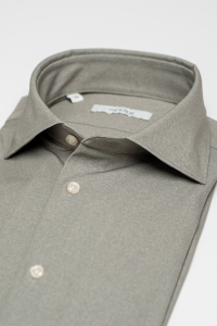 Mooi opgevouwen groen shirt met off-white parelmoeren knopen gemaakt van techno comfort materiaal in 4 way stretch.