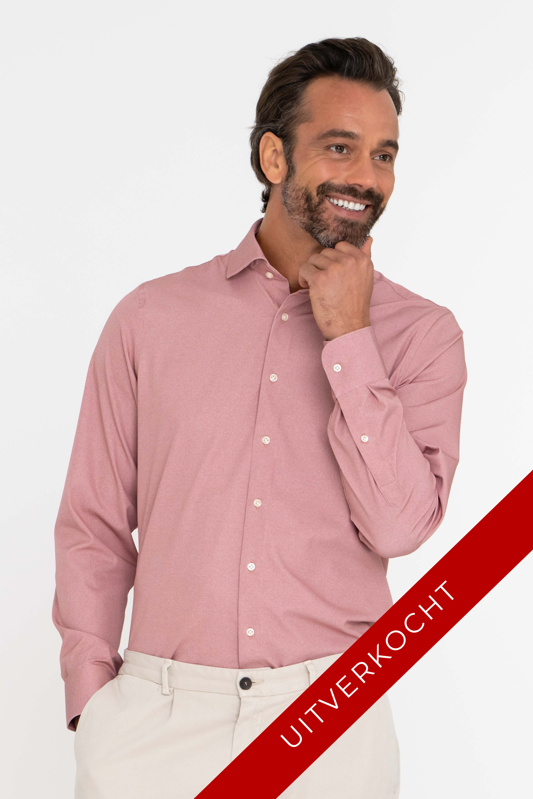Lachende man in rose Techno Comfort Shirt met hand aan zijn kin.